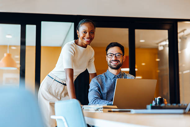 istock Smiling colleagues working together in bright office environment 2217458683