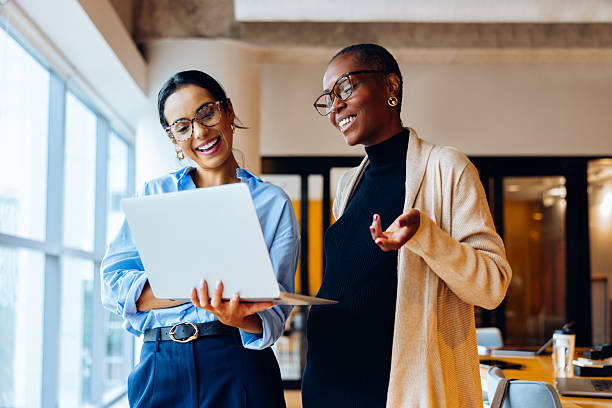 istock Two businesswomen discussing work while using a laptop in an office setting 2217458781