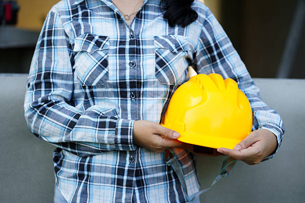Safety first worker holding yellow hard hat construction site professional image outdoor close-up occupational safety