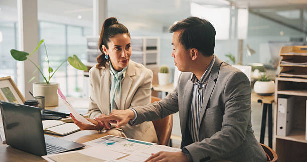 istock Collaboration, paperwork and planning with business people in office for development or discussion. Documents, laptop and meeting with corporate employee team at work for conversation or strategy 2217463857