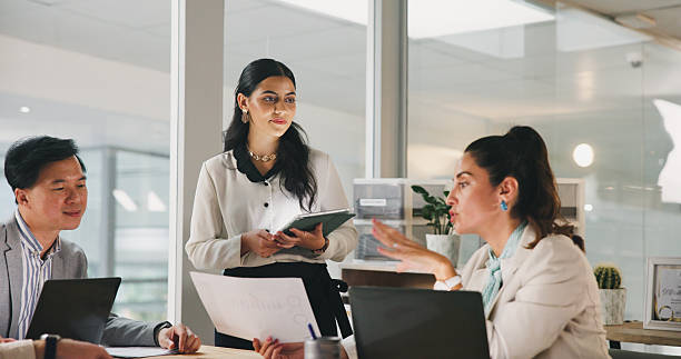istock Collaboration, documents and feedback with business people in office for development or discussion. Laptop, meeting and tablet with team in corporate workplace for conversation, strategy or update 2217463885
