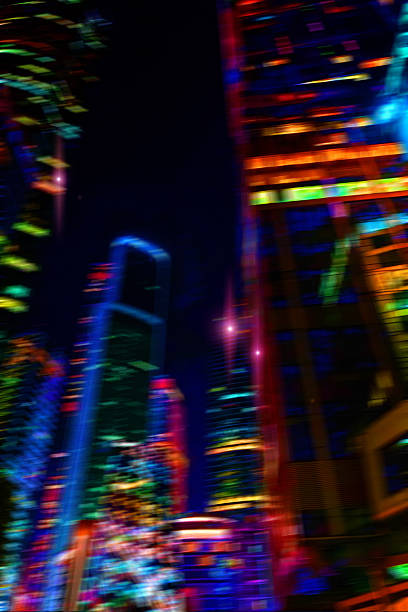 Night city lights. Bright glowing lights of a metropolis district under twilight sky in evening on blurred background