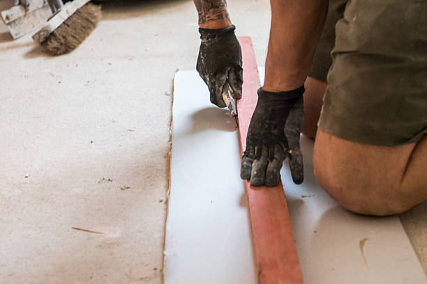 istock Construction worker cutting piece of board with sharp knife and straight edge 2217467399