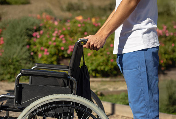 istock Nurse pushing wheelchair in a park 2217467755
