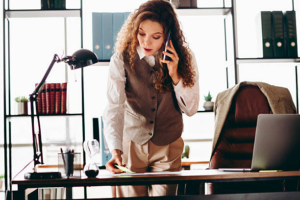 istock Young Businesswoman Talking on Phone While Working in Modern Office Setting 2217468921