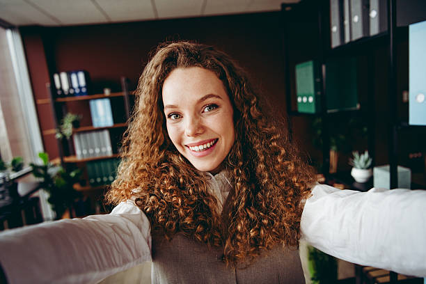 istock Confident Young Businesswoman Taking a Professional Selfie in a Modern Office Setting 2217468996