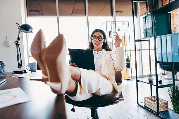 istock Charming businesswoman in formal attire working in a modern office setting, engaged during a call, exuding efficiency and charm 2217469564