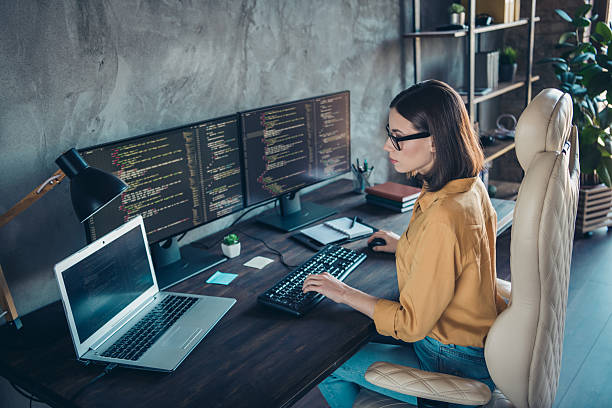 istock Profile side view portrait of attractive focused skilled girl web developer using laptop at workplace workstation indoors 2217473135