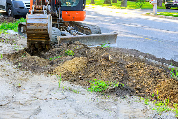 istock Excavator working on road improvement project at residential area during work day 2217479700