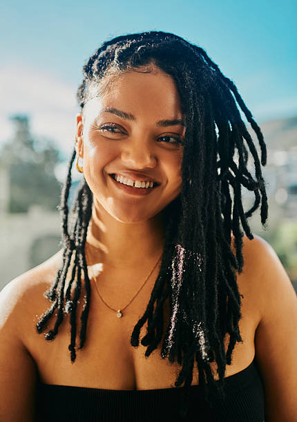 istock Smiling Woman with Black Dreadlocks in Sunlight 2217480028