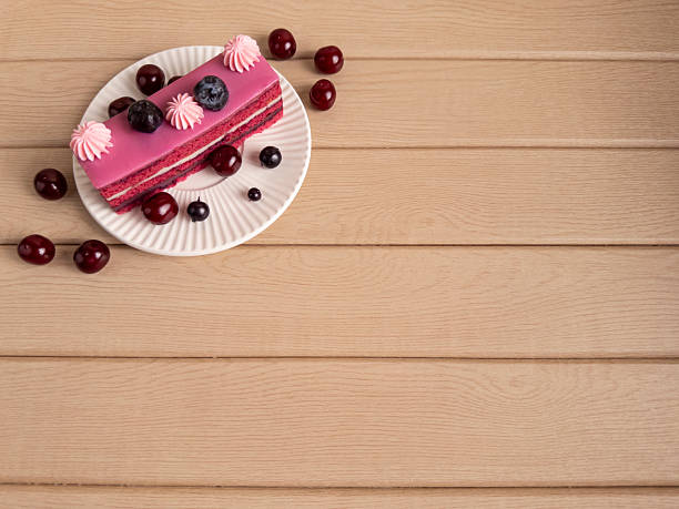 Elegant Berry Cake Slice on Wooden Surface