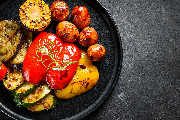 istock Meat steaks with vegetables and herbs at black board. 2217481025
