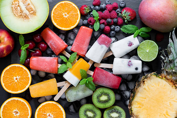 Delightful assortment of berry ice cream and fresh fruits arranged flat on a dark surface, showcasing vibrant colors and textures, perfect for a refreshing summer treat