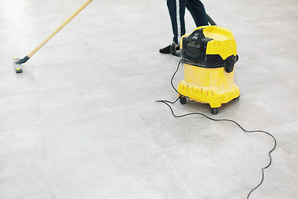 istock Cleaning service worker sweeping and vacuuming a large gray tiled floor 2217485266