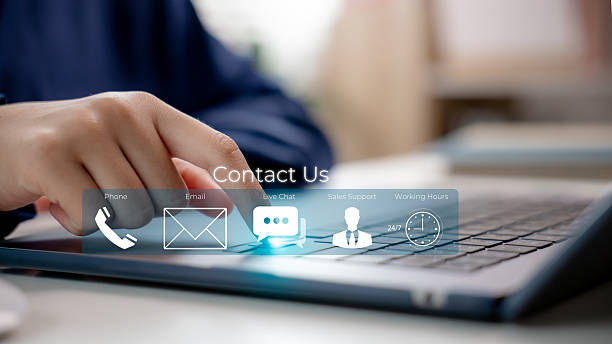 istock A business hand touches the Contact Us icon on a digital touchscreen laptop interface, a customer support concept with email, phone, live chat, and 24/7 service icons for corporate communication. 2217486716