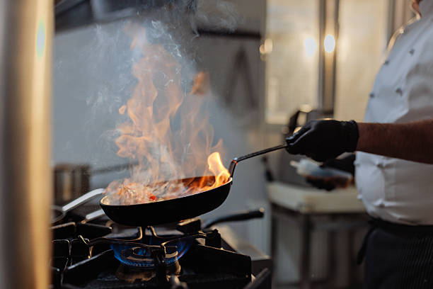 istock Chef flambeing food in a pan in a restaurant kitchen 2217486804