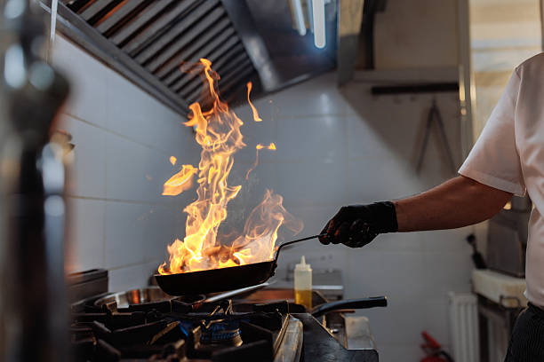 istock Chef flambeing food in a pan in a restaurant kitchen 2217486810