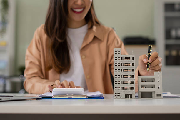 istock Home loan officer uses a calculator with a house plan. 2217490297