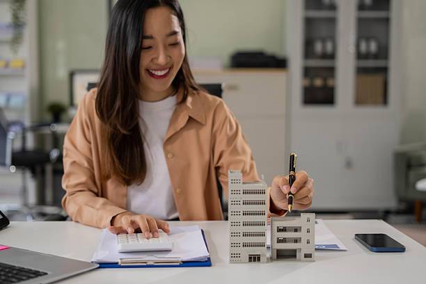 istock Home loan officer uses a calculator with a house plan. 2217490316