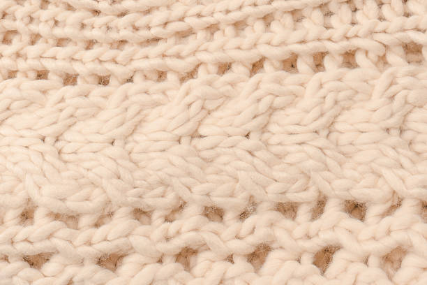 istock A fragment of beige knitted fabric, knitted from white sheep wool. 2217492085