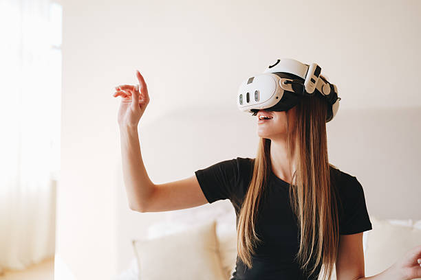 istock Young woman enjoys virtual reality experience while interacting with digital elements in a bright indoor space 2217492560