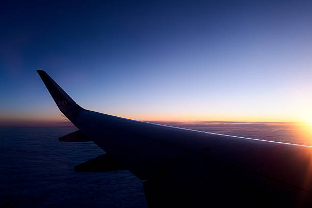 istock View from the airplane window on a beautiful sunset above the clouds. 2217497284