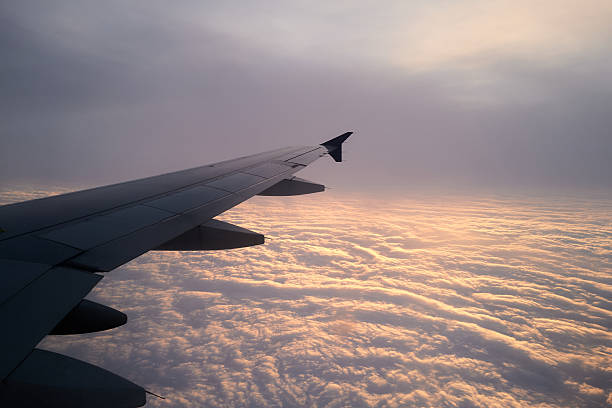 istock View from the airplane window on a beautiful sunset above the clouds. 2217497344