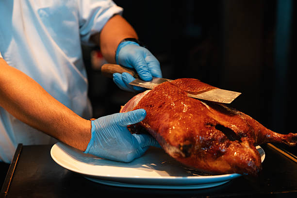 istock Chef Carving Crispy Peking Duck for Serving 2217498153