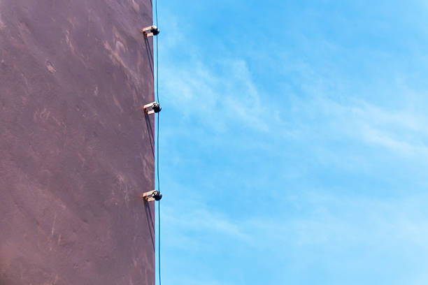 A vibrant building facade meets a clear blue sky, showcasing modern architecture with striking lines and textures in a minimalist design.