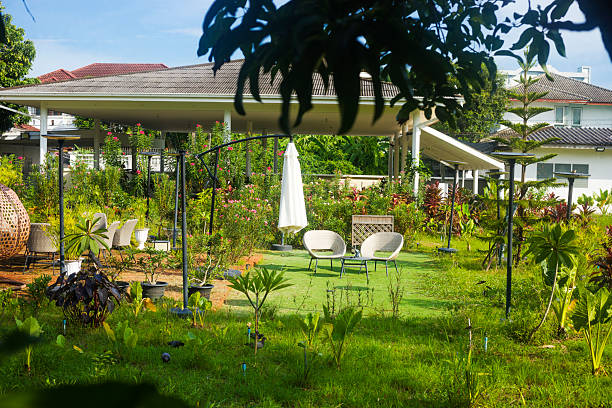 View into larger garden of thai home with many plants and some seats placed in the garden. Scene is in area between CRU university and junction of Ratchadaphisek Road and Phahonyothin Road