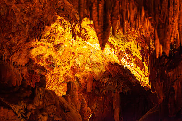 istock Stalactites and stalagmites in a cave illuminated by multi-colored light. A tourist attraction inside the mountain. 2217499415