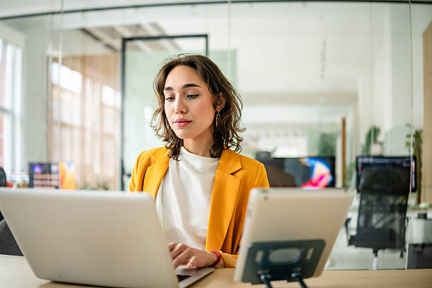 istock Young businesswoman working on laptop in modern office environment while focused on tasks and engaged in her professional duties 2217500741