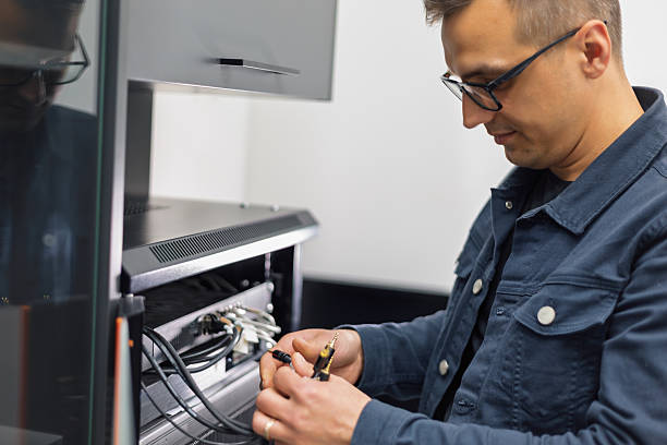Sound technician plugging audio cables into amplifier in professional recording studio