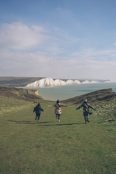Friends enjoy headlands above sea, springtime