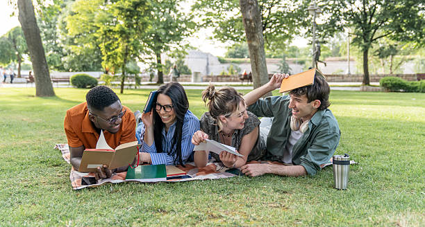 istock Students relaxing and studying together lying on grass in a park 2217501888