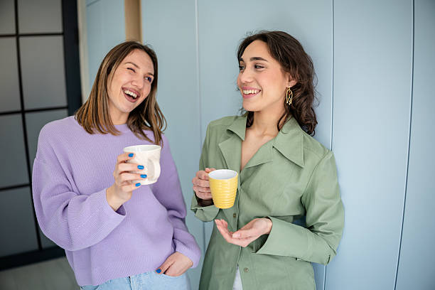 istock Young businesswomen engage in lively conversation while enjoying coffee at a modern office setting 2217502015