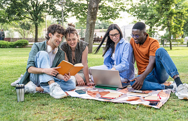 istock Students studying together in the park using laptop and textbook 2217502192