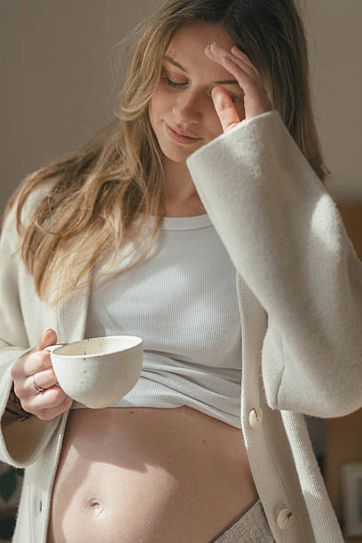 istock Pregnant woman relaxes with tea cup 2217502318