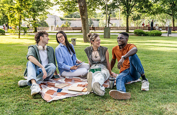istock University students relaxing together in a park 2217503566