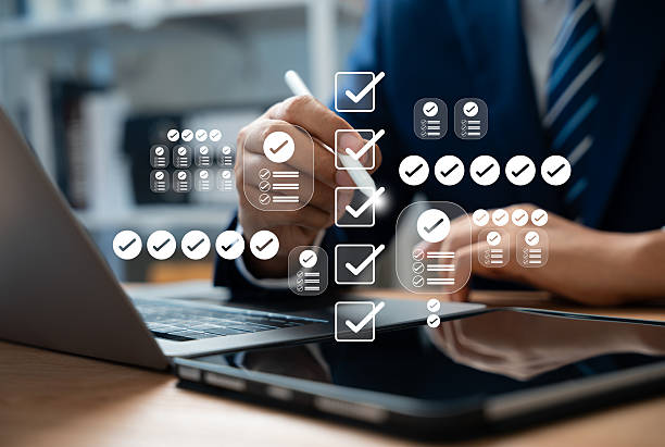 istock Online survey and checklist assessment, Digital questionnaire, Businessman use tablet to complete a digital form, making evaluation and selecting correct answers marked with check marks. 2217505014