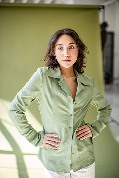 Confident young businesswoman in a stylish black jacket sits in an office chair, exuding professionalism and ambition in a sleek corporate setting