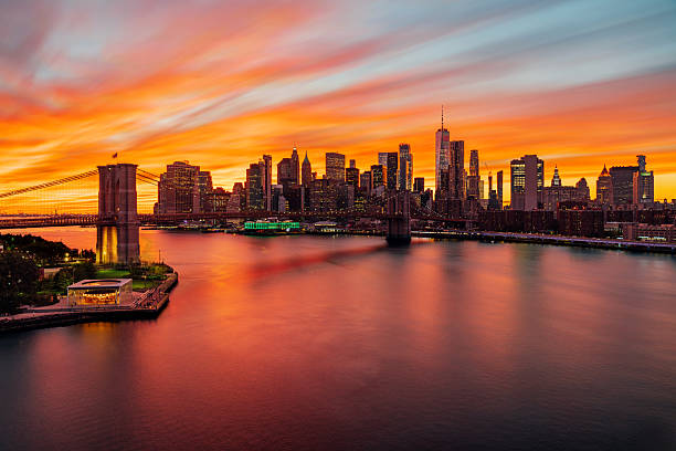 New York City skyline from elevated point of view. Colorful sky at sunset. Manhattan skyline seen from Manhattan Bridge. Super long exposure.