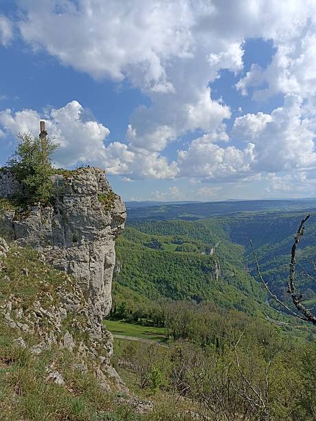 istock Old stone Catholic cross overlooking a karst cliff above the Loue Valley 2217514638