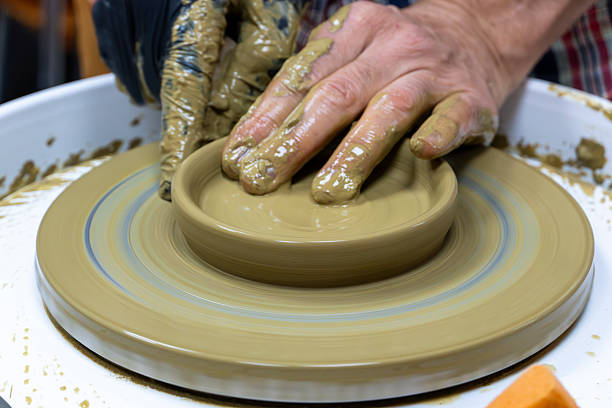 Creating a ceramic bowl in a pottery class. Wheel throwing. Learning how to model clay into different shapes with pottery wheel