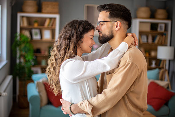 istock Young couple sharing a tender embrace at home 2217520889