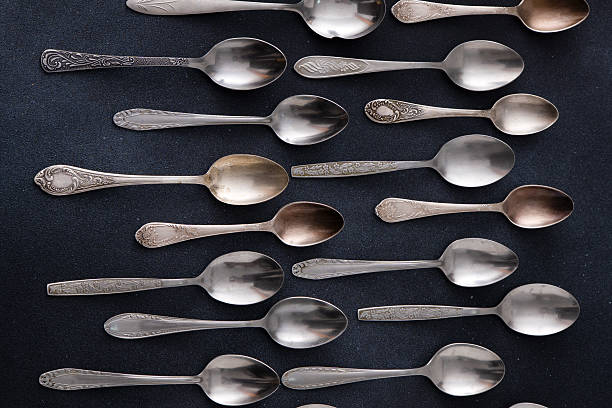 istock Set of different spoons. Silver cutlery on a black background. Spoon on the table 2217520891