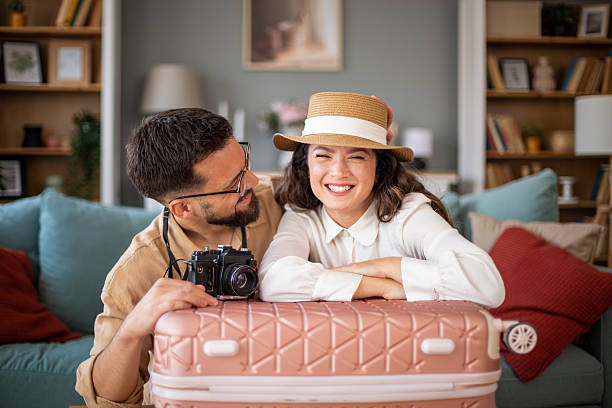 istock Young couple smiling and leaning on a suitcase ready for vacation 2217521699