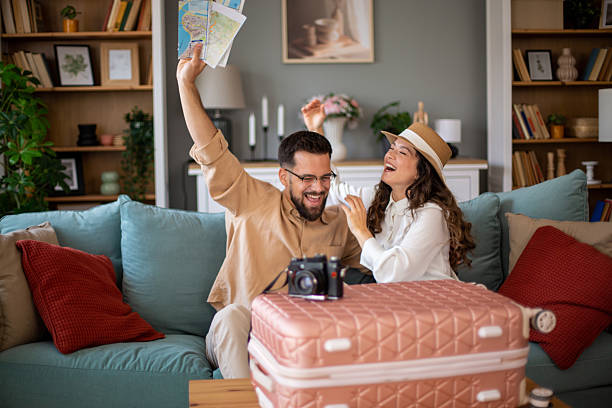 istock Excited couple planning a trip with maps and suitcase 2217521839