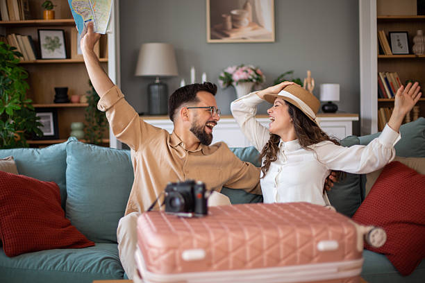 istock Excited couple planning vacation with map and suitcase 2217521841
