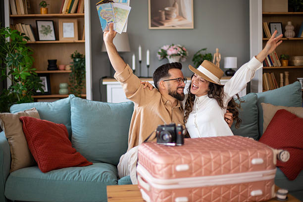 istock Excited couple planning a trip with maps and suitcase 2217521883